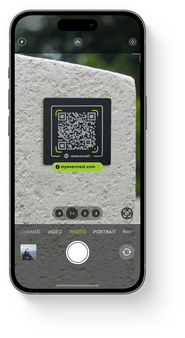 Smartphone displaying a QR code on a tombstone, showcasing Evercrest's easy mobile access to digital memorials